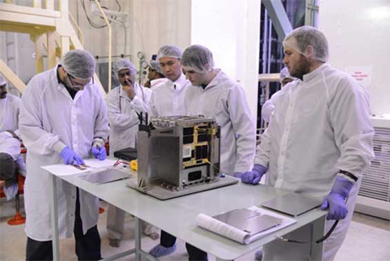 Figure 1: (Left to right, foreground) Mission Manager Grant Bonin, Propulsion Engineer Ben Risi, and Systems Engineer Scott Armitage preparing for launch vehicle integration